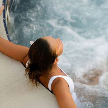 A woman in a white bikini is relaxing in a hot tub.