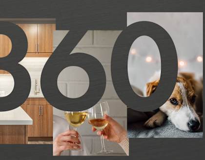 a person holding a glass of wine with a dog on the floor