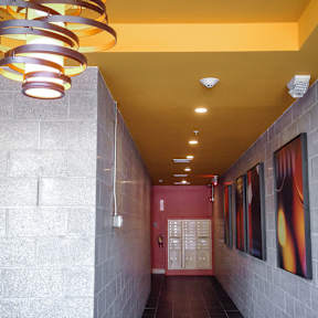 A hallway with a yellow ceiling and a red door.