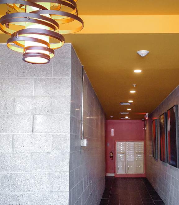A hallway with a yellow ceiling and a red door.