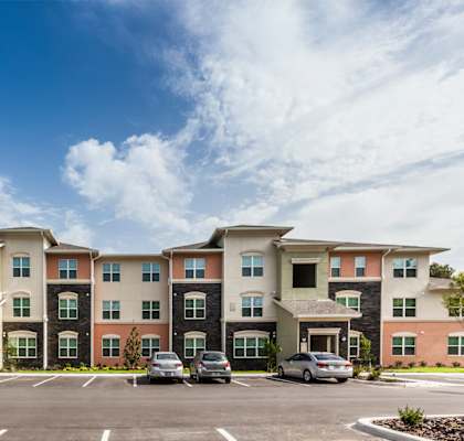 a parking lot with cars in front of an apartment building