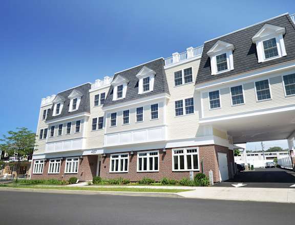 a large building with a gray roof and white siding