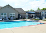 Thumbnail 1 of 22 - Outdoor pool located next to the clubhouse with lounge chair seating