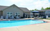Thumbnail 1 of 22 - Outdoor pool located next to the clubhouse with lounge chair seating