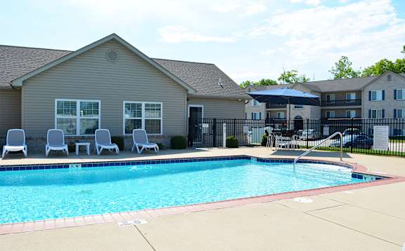 Outdoor pool located next to the clubhouse with lounge chair seating
