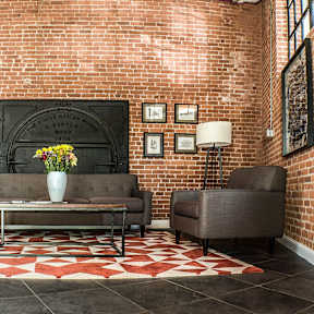 Lobby seating area with exposed brick wall at Star Mill Lofts Apartments, Middleboro