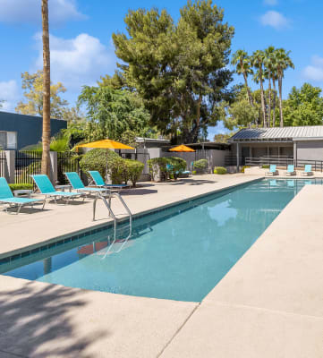 Community Swimming Pool with Pool Furniture at Lakeside Casitas Apartments in Tucson, AZ-Hero.