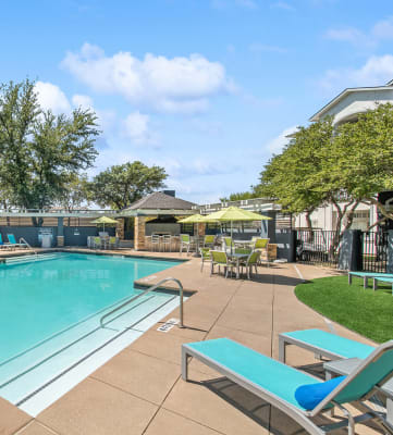 Community Swimming Pool with Pool Furniture at Allure North Dallas Apartments in Dallas, TX-HERO.