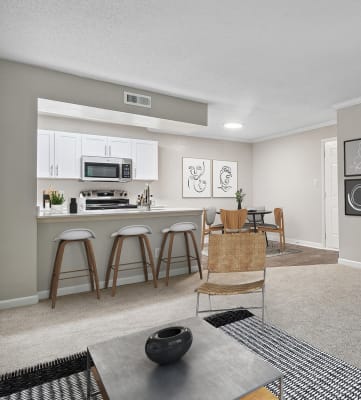 Model Living Room and Dining Room with View of Kitchen at Arbor Village Apartments in Charlotte, NC-HERO.