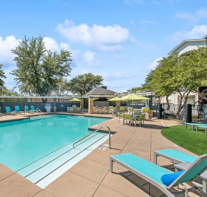 Community Swimming Pool with Pool Furniture at Allure North Dallas Apartments in Dallas, TX-HERO.