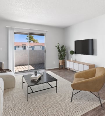 a living room with white walls and a sliding glass door that leads to a patio