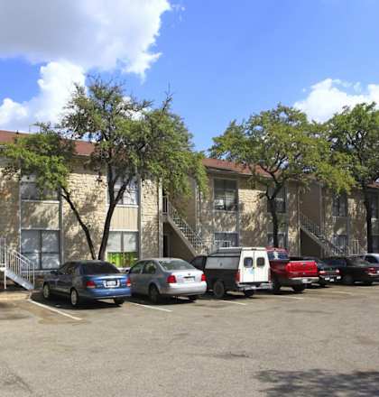 A parking lot with cars and a building in the background.