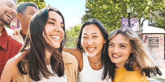 a group of young women and men are standing together and smiling
