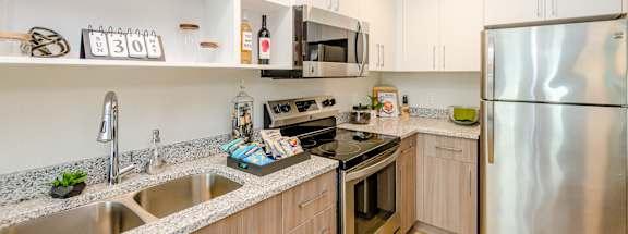 A modern kitchen with a stainless steel refrigerator, a microwave, and a sink.