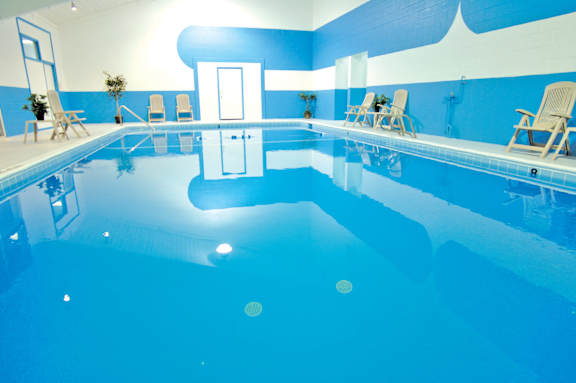 A large indoor swimming pool with a blue tint.