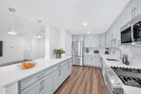 a large kitchen with white cabinets and stainless steel appliances