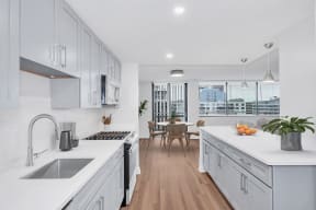 an open kitchen and dining room with white cabinets and white counter tops
