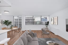 an open living room with a couch and a table and chairs and a large window