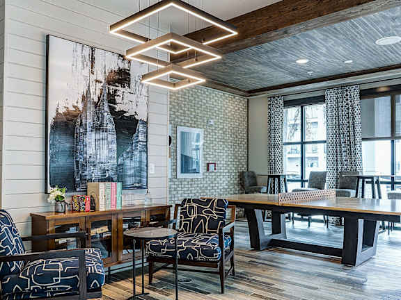 A modern living room with a large abstract painting on the wall and a wooden floor.