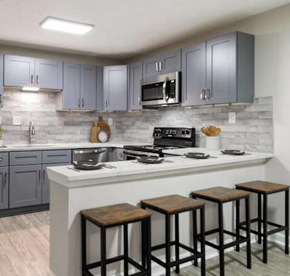 a kitchen with stainless steel appliances and a counter with stools