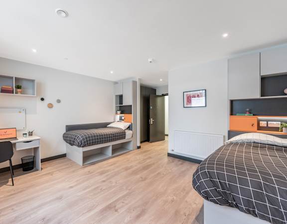 a bedroom with a bed and a desk in a room