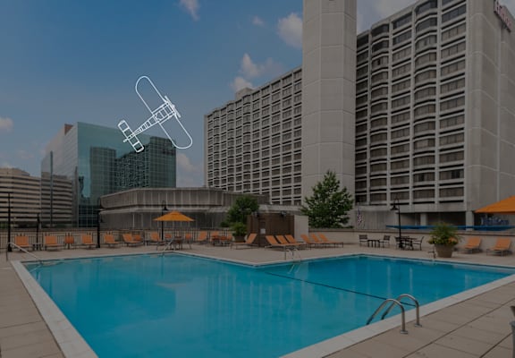 a swimming pool at a hotel with a building in the background