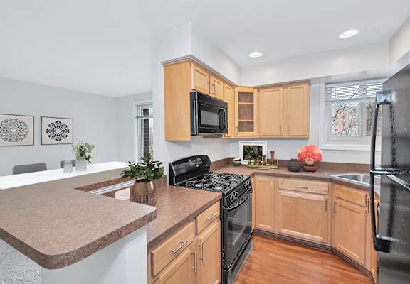 a kitchen with maple cabinets and black appliances