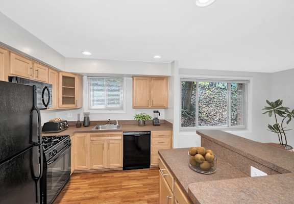 a kitchen with wooden cabinets and black appliances
