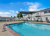 Thumbnail 1 of 10 - A swimming pool in a sunny day with a blue sky.