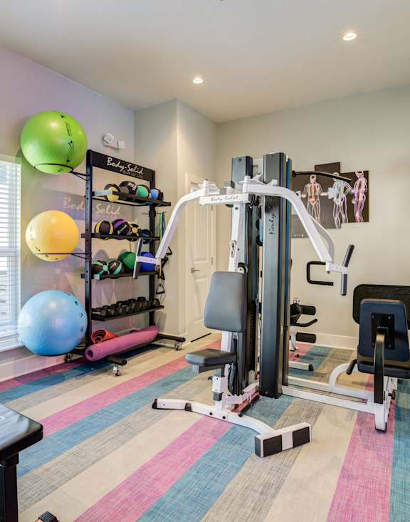 Mandarin Bay waterfront apartments in Jacksonville, FL with onsite fitness center with a bench, exercise balls, and weight machines.