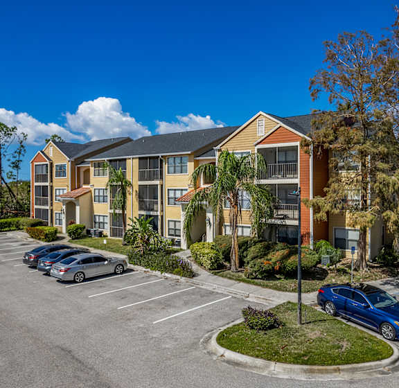 A parking lot in front of a multi-story apartment building.