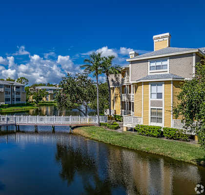 A serene residential area with a bridge over a calm water body.