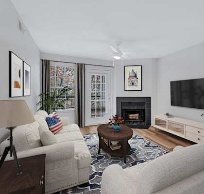 A living room with a fireplace, a couch, a chair, a coffee table, and a television.