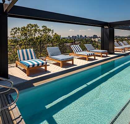 A large outdoor swimming pool with lounge chairs at Seminary Towers, Alexandria