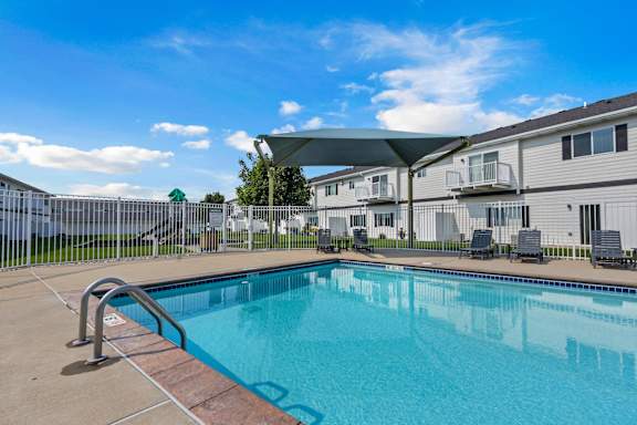 A swimming pool in a sunny day with a blue sky.