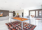 Thumbnail 6 of 7 - A pool table is in the middle of a room with a rug on the floor.