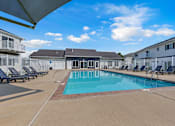 Thumbnail 2 of 10 - A swimming pool surrounded by sun loungers and apartment buildings.