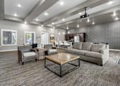 Thumbnail 8 of 10 - A spacious living room with a grey sofa, a wooden coffee table, and a television mounted on the wall.