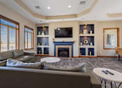 Thumbnail 3 of 9 - A living room with a grey couch and a fireplace.
