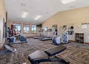 Thumbnail 7 of 9 - A gym with a variety of equipment including treadmills, weights, and exercise machines.
