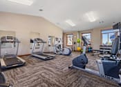 Thumbnail 6 of 9 - A gym with treadmills, elliptical machines, and weights.