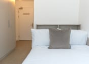 Thumbnail 2 of 8 - a bedroom with a bed with two pillows and a door