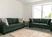Thumbnail 1 of 8 - a living room with two green couches and a rug
