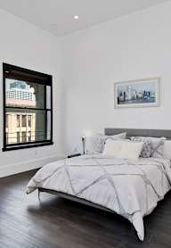 A bedroom with a large bed and a chair.