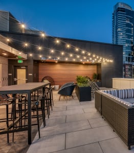a rooftop patio with a city skyline at night