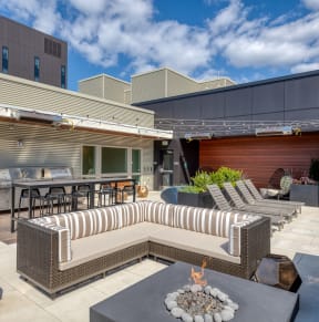 a patio with couches and tables and a fire pit