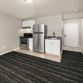 A kitchen with a black floor and white walls.