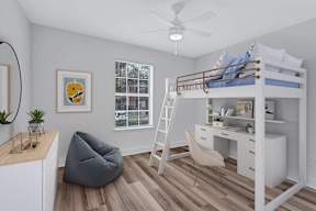 A room with a bunk bed, desk, chair, and a hanging chair.