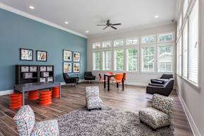 a living room with a table and chairs and a ceiling fan