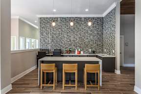 a kitchen with a large island with four chairs in front of it